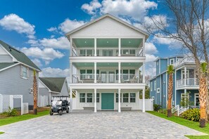 A two-story residential building with a central entrance, a covered front porch, and a driveway.