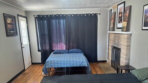 Ein Schlafzimmer mit zwei Betten, einem Kamin und einer Deckenleuchte.