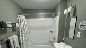 Ein Badezimmer mit Badewanne, Toilette, Waschbecken und Duschvorhang.