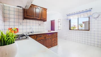 Une cuisine avec des meubles en bois, un plan de travail en marbre et une fenêtre donnant sur un beau paysage.