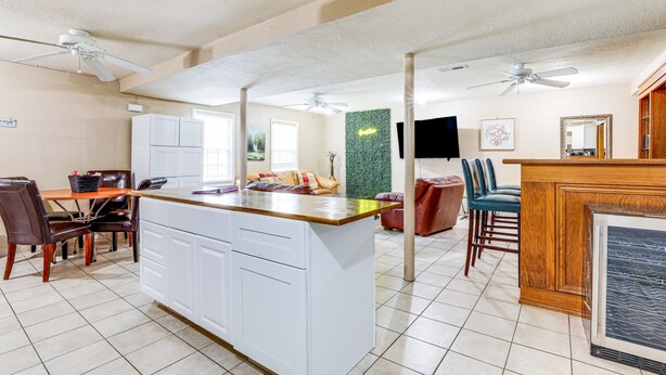 A spacious kitchen with a central island, white cabinetry, and a dining area with chairs. - Pet-Friendly Lilburn Duplex w/ Patio & Grills! (Lilburn)