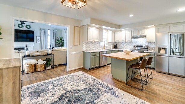 A modern kitchen with a central island, stainless steel appliances, and a herringbone-patterned backsplash. - Peaceful Queenstown Home w/ Deck & Grill! (Queenstown)