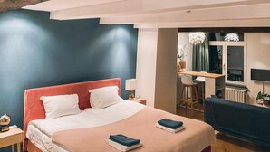 A modern hotel room with a large bed, a desk, and a chair.