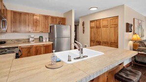 Una cucina moderna con mobili in legno, elettrodomestici in acciaio inossidabile e un'isola centrale con lavello.