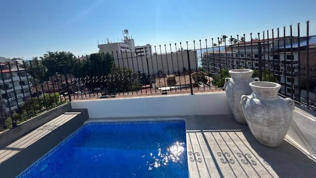 A rooftop pool with a clear view of buildings in the background.
