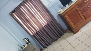 Una cocina con refrigerador, tetera y armario de madera.