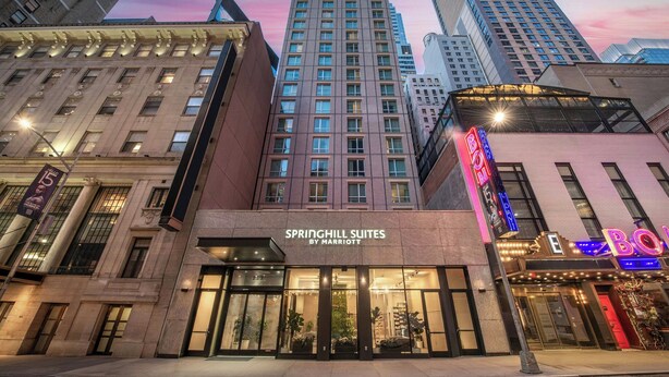 Un hôtel doté d’une enseigne lumineuse, de grandes fenêtres et d’une façade moderne.