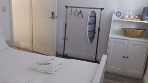 A hotel room with a bed, a wardrobe, a drying rack, and a small table with a basket. - Citybreaks Rooms (Liverpool)