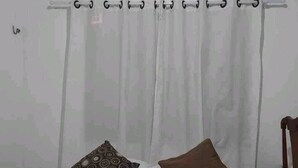 A bedroom with a bed, two pillows, a wooden chair, and an air conditioning unit on the wall. - Suíte com ar Condicionado Próximo ao Estádio Mangueirão e Mangueirinho (Belem)