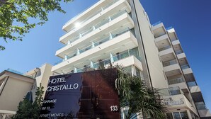 A multi-story hotel with balconies and a large sign advertising 'Hotel Cristallo' and 'Garage'.