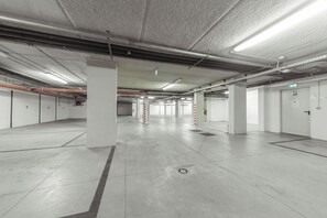 A spacious, well-lit underground parking garage with concrete floors and white walls. - Cristallo Rimini (Rimini)