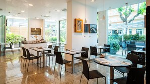 A modern restaurant with a clean interior, large windows, and a view of the outdoors.