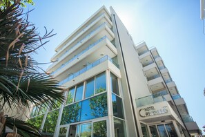 A modern hotel with multiple floors, large windows, and a clear view of the sky. - Cristallo Rimini (Rimini)