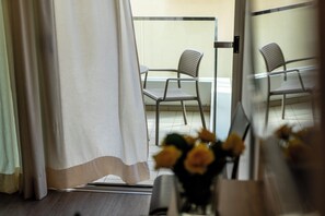 A room with a sliding glass door leading to an outdoor seating area with two chairs. - Cristallo Rimini (Rimini)