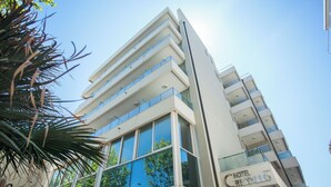 A modern hotel with multiple floors, large windows, and a clear view of the sky. - Cristallo Rimini (Rimini)