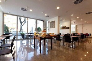 Una àmplia zona de dinar amb grans finestres, terres polides i lluminàries modernes.