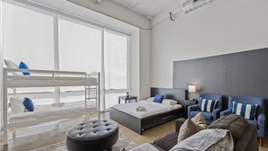 A modern bedroom with a bunk bed, a large bed, a sofa, and a nightstand. - Modern Dallas Retreat with Pool & In-Unit Laundry (Dallas)