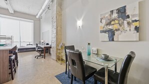 A modern office space with a glass table, leather chairs, and a large abstract painting on the wall. - Modern Dallas Retreat with Pool & In-Unit Laundry (Dallas)