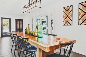 Un'area pranzo con un tavolo di legno, sedie nere e vasi decorativi.