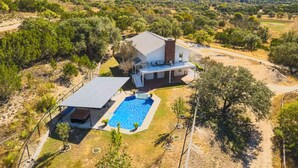A modern house with a swimming pool, surrounded by a natural landscape. - Relaxation+Pool & Hot Tub+Views (Comfort)