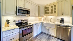 A modern kitchen with white cabinets, stainless steel appliances, and a marble countertop. - Mountain Getaway Retreat - 4br + loft  (Beech Mountain)