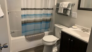 Une salle de bain équipée d’une douche, de toilettes, d’un lavabo et d’un porte-serviettes.