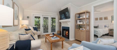 Una sala de estar moderna con chimenea, televisión y un área de estar acogedora.