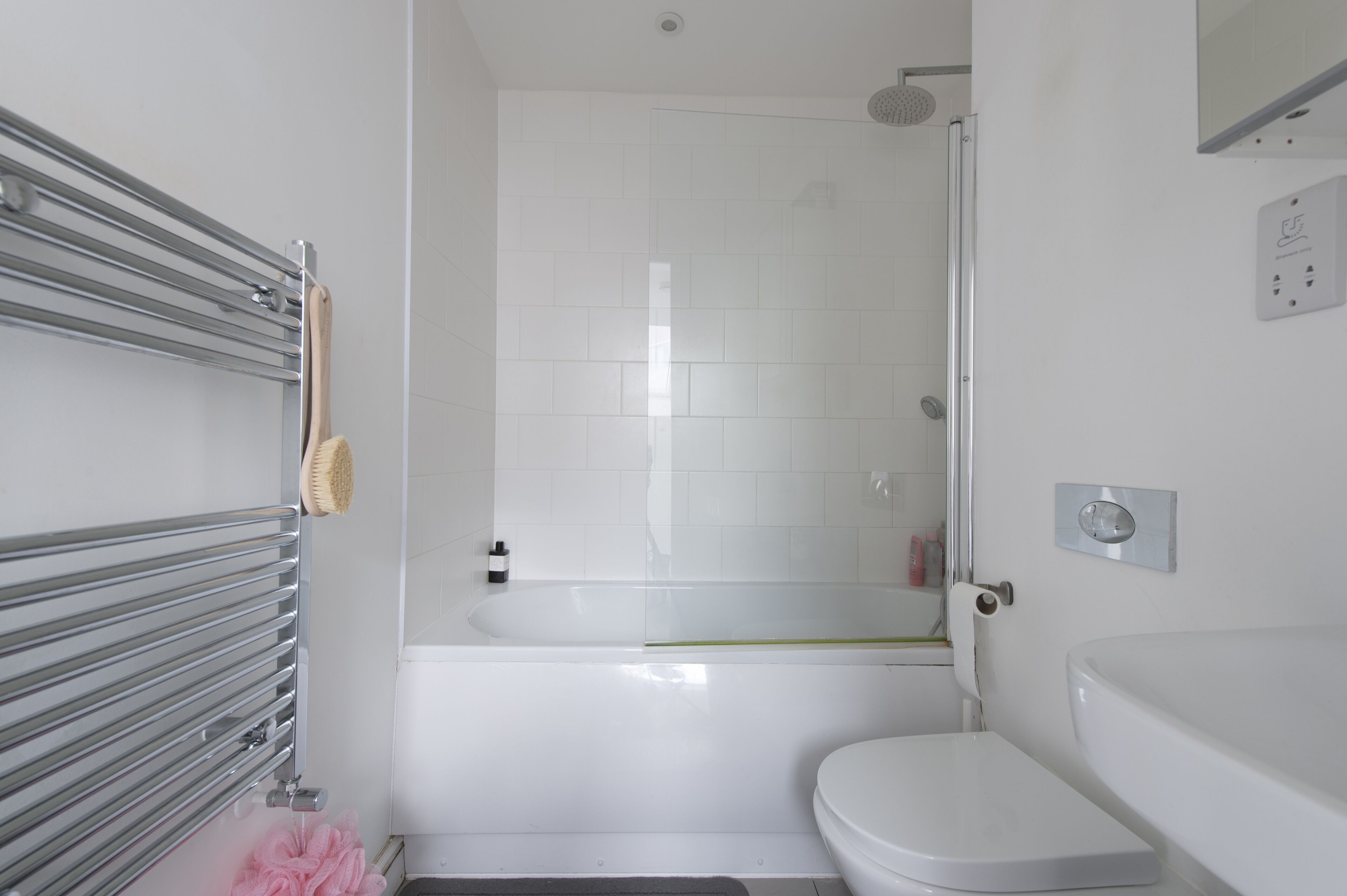 A modern bathroom with a bathtub, toilet, and a shower.