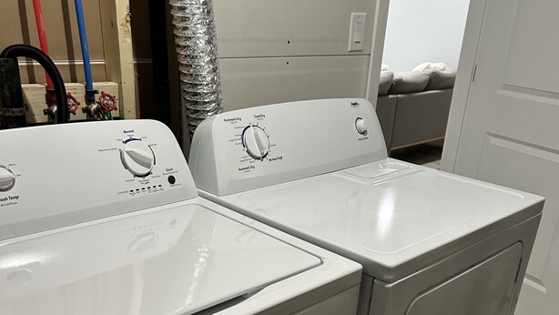 Twee voorladers wasmachines in een wasserij, met een deur op de achtergrond.