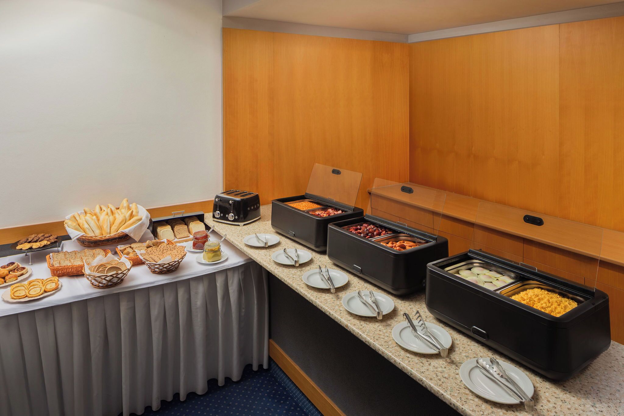 A buffet setup with various food items and utensils.