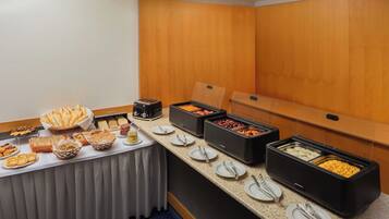 A buffet setup with various food items and utensils.