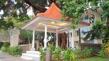 Situated in a lush garden, this traditional-style gazebo offers a serene atmosphere.