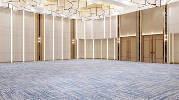 A spacious, well-lit conference room with a patterned carpet, high ceilings, and modern lighting fixtures.