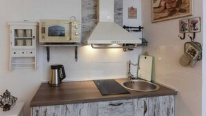 A compact kitchen with a microwave, stove, and sink. - Figura suites 1 Studio in the Old town (Dubrovnik)