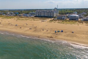 An aerial view of a beach with a hotel complex in the background.