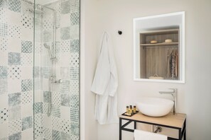 A modern bathroom with a glass shower, a white sink, and a wooden vanity. - Marina Drach (Manacor)
