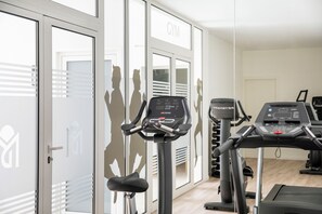A gym with exercise equipment, including treadmills and stationary bikes, and a door labeled "GYM". - Marina Drach (Manacor)