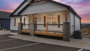 Un bâtiment avec des fondations en pierre, des poutres en bois et un porche doté d’une balustrade.