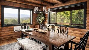 A wooden dining room with a large table, chairs, and a chandelier. - Luxe Log Cabin, Mountain Views, HotTub, Secluded (Rileyville)