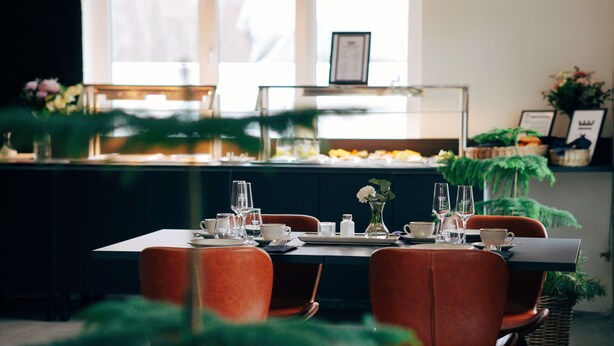 Un comedor con bufé, sillas y una mesa dispuesta para una comida.