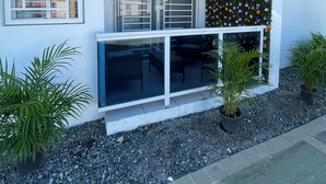 A modern building with a balcony, large windows, and a decorative wall with flowers. - Helios Luxurious Condo At Caleta (La Romana)