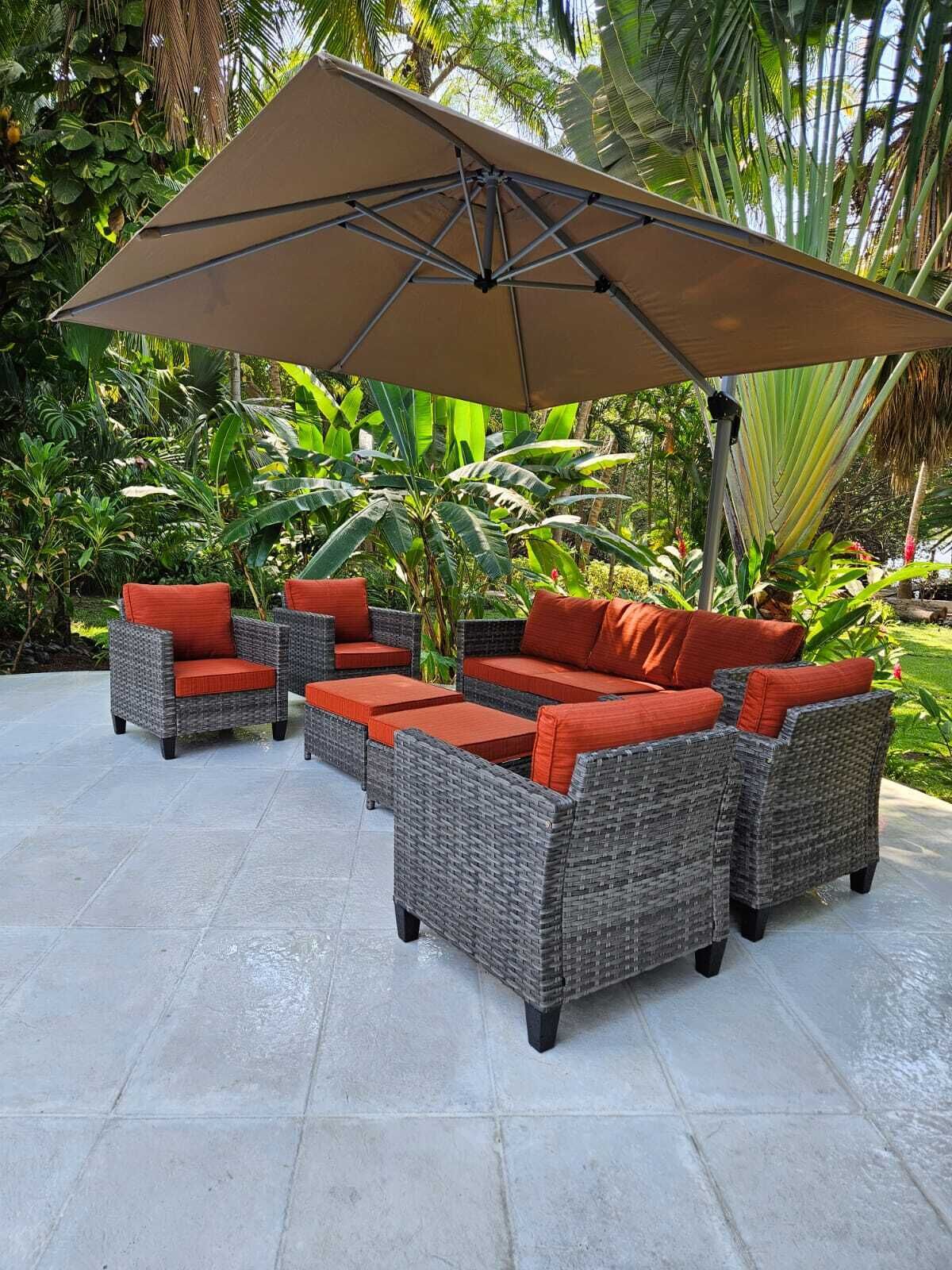 Un espace patio aménagé avec des meubles en osier et un grand parasol.
