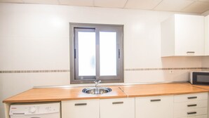 Una cocina compacta con lavadora, lavaplatos y microondas.