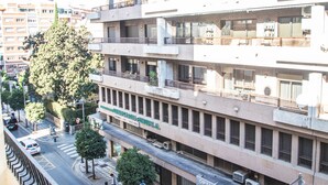 Un edificio de varios pisos con balcones, unidades de aire acondicionado y un letrero que indica un centro de negocios.