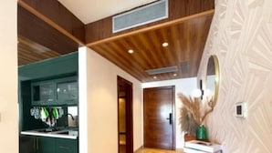 Una cocina moderna con gabinetes verde oscuro y techo de madera.