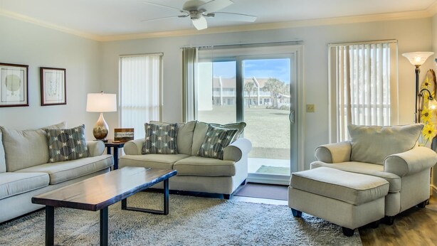 A living room with a sofa, armchair, coffee table, and a ceiling fan. - 10 A, One Bedroom Condo (Miramar Beach)