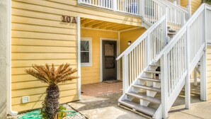 A two-story yellow building with a white staircase and a door marked "10A". - 10 A, One Bedroom Condo (Miramar Beach)