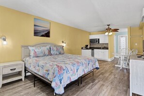 Cozy retreat with a nautical-themed bed, kitchenette, and dining area, perfect for travelers.