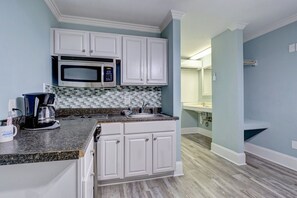 Refrigerador, microondas, utensilios de cocina, mesa de comedor