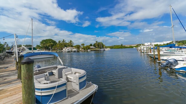 A marina with boats docked, a wooden dock, and a clear sky. - ALL BRAND-NEW Waterfront room-Heated Pool, Tiki Bar, Gym (Sarasota)